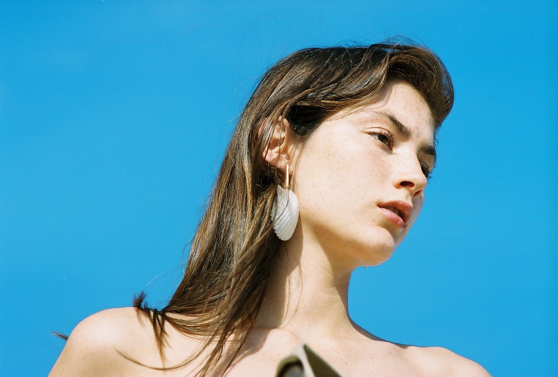 Sunlit fashion portrait against a bright blue sky, by Mel Tjoeng